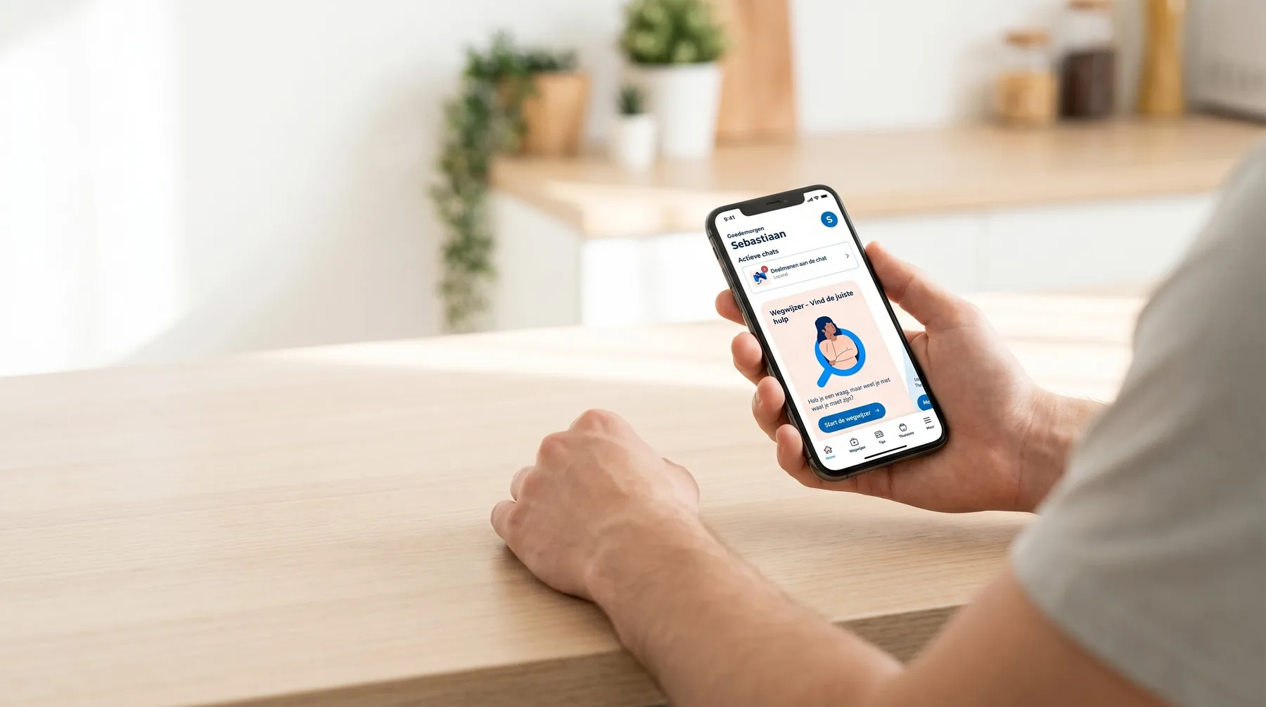 Zilveren Kruis app on a phone, held above a kitchen table